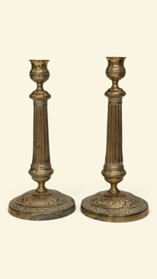 pair of antique brass candlesticks on a white background