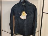 une veste en jean accrochée à un portant dans un magasin de vêtements