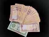 une liasse de billets posée sur une table noire