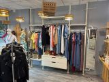 une femme debout dans un magasin de vêtements, en train de regarder un portemanteau