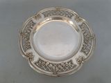 an antique silver plate with a floral design on the rim