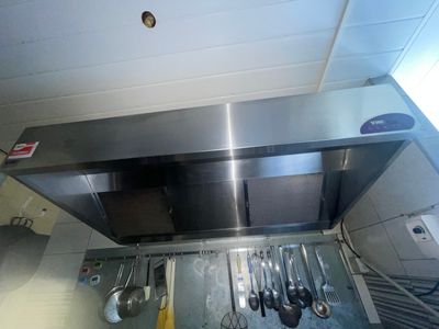 une plaque de cuisson en acier inoxydable à laquelle sont suspendus tout un tas d'ustensiles