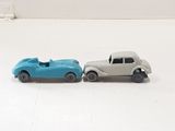 two toy cars that are sitting side by side on a white surface
