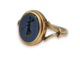 an image of a gold ring with a silhouette of a woman holding a tennis racquet