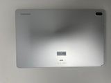 the back of a silver laptop computer sitting on top of a white table