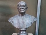 un buste d'homme assis sur un socle