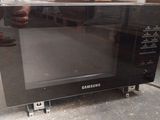 a microwave that is sitting on the floor in a warehouse