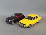 two toy cars are sitting side by side on a gray surface