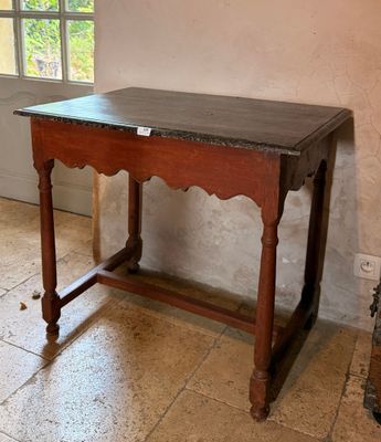 une table en bois avec un plateau en marbre dans une pièce