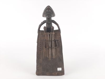 a wooden sculpture of a woman holding a musical instrument