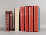 trois livres sont alignés les uns à côté des autres sur une surface grise