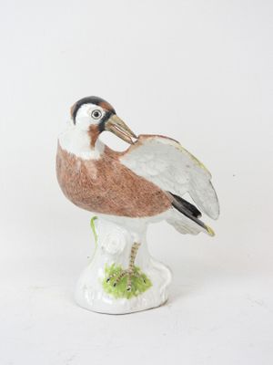 porcelain figurine of a bird on a pedestal on a white background