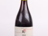 la bouteille de vin rouge est posée sur une surface blanche