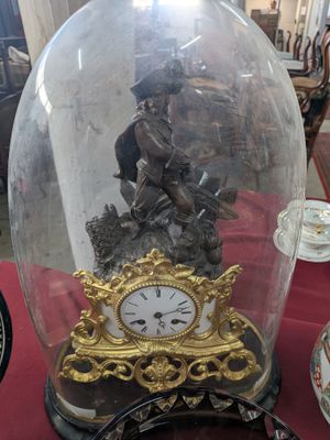 a clock under a glass dome on a table