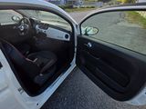 a white car with its door open sitting on the side of the road