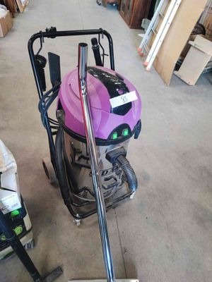 un aspirateur rose posé par terre