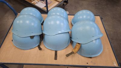 several helmets are lined up on a table in a warehouse