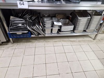 de nombreuses casseroles et poêles posées sur une étagère dans la cuisine