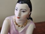 a figurine of a woman sitting on a table