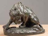bronze statue of a lion on a rock on a table