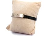 leather and silver bracelet on a pillow on a white background