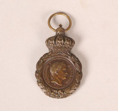 une vieille médaille en bronze surmontée d'une couronne