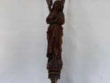 une image représentant une statue d'ange posée sur un poteau en bois