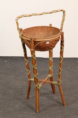 a wicker basket on a stand on the floor