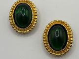 une paire de boucles d'oreilles vertes et dorées