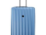 La valise bleue repose sur ses roulettes, posée sur une surface blanche.