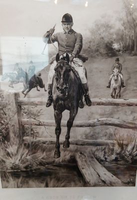 une photo d'un homme à cheval, avec un chien en arrière-plan