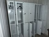 a closet in the corner of a room with clothes hanging on it