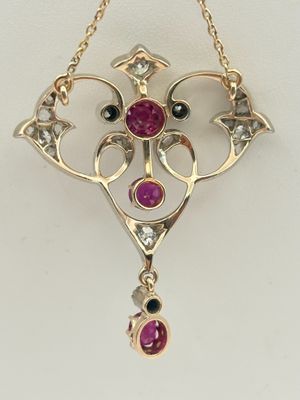 un gros plan sur un collier en or orné d'un pendentif en pierre rose