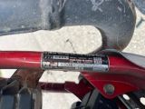 un gros plan sur le guidon d'un vélo rouge sur lequel est collé un autocollant