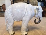 an elephant that is standing on the floor in front of a fire place