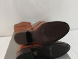pair of brown shoes sitting on top of a white surface