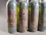 four empty bottles of wine are lined up in a row