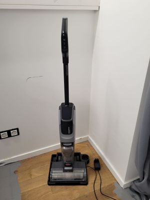 the vacuum is sitting on the floor in the corner of the room