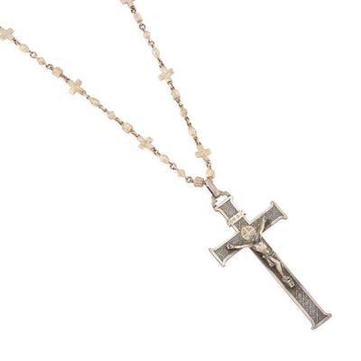 gros plan d'une croix sur une chaîne sur fond blanc