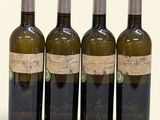 trois bouteilles de vin posées les unes à côté des autres sur une surface blanche
