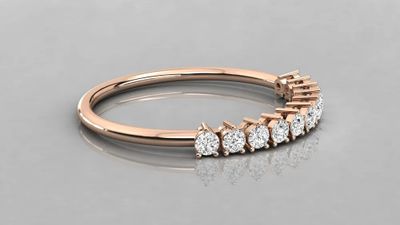 a rose gold ring with five diamonds on a reflective surface
