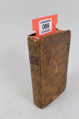 un vieux livre sur lequel est collée une étiquette rouge