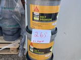 une pile de seaux posée par terre à côté d'un tas de tonneaux