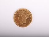 gros plan d'une pièce d'or sur une surface blanche