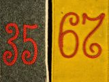 three different colored tags with numbers on them on a black surface