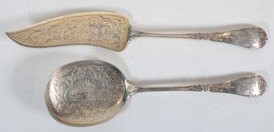 deux cuillères en argent et un repose-cuillère posés sur une surface blanche