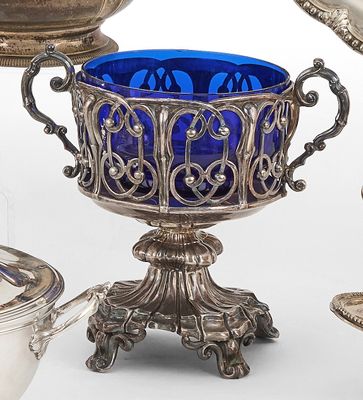 un verre bleu posé à côté d'une assiette en argent