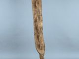 une sculpture en bois représentant la tête d'une femme, posée sur un socle noir