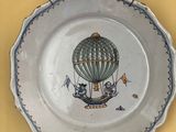 une assiette sur laquelle est peint une montgolfière
