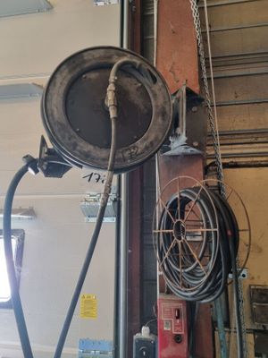 une photo d'un garage avec un tuyau d'arrosage fixé au plafond